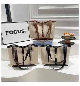 Detailed set of three canvas tote bags with leather trim and metal twist lock details