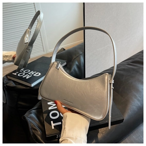 Detail of silver metallic baguette bag with pleated texture and silver shoulder strap