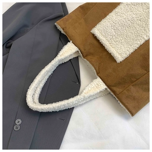 Detail of plush tote bag showing brown suede and white faux fur texture patchwork