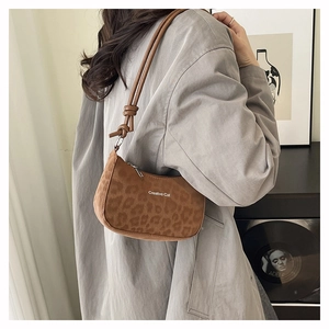 Detailed view of brown leopard print hobo bag with knotted leather shoulder strap