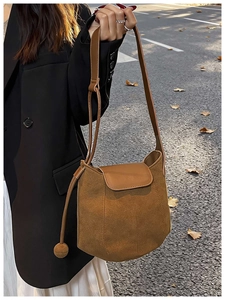 Détail du sac seau citrouille en daim marron avec gland sphérique sur une rue d'automne