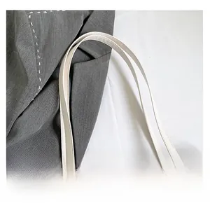 Détail de la texture du sac cabas blanc cassé avec bandoulière fine en cuir