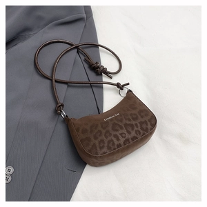 Close-up of leopard print underarm bag with Creative Cat text on textured fabric