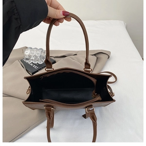 Top view of spacious interior compartments and black lining in brown shoulder bag