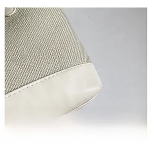 Détail de la texture en tissu tissé beige et des coins en cuir blanc avec coutures
