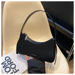 Detail of minimalist black crescent underarm bag with matte leather and metal zipper