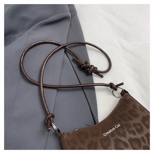 Detail of leopard print shoulder bag with Creative Cat logo and metal ring strap link