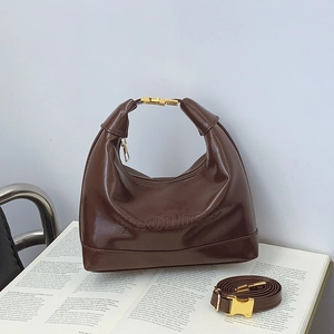 Borsa a bauletto marrone scuro con manici dorati e tracolla regolabile in pelle