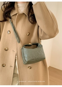 Detail of Morandi green corduroy crossbody bag worn with a stylish camel wool coat