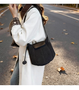 Chic canvas bucket bag with dark brown flap and drawstring detail in autumn street scene