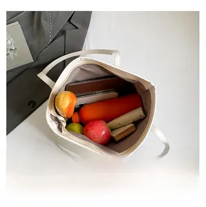 Intérieur d'un grand cabas en cuir blanc montrant l'espace pour ordinateur et accessoires