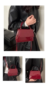 Détail du sac en cuir verni rouge avec boucles dorées et rabat brillant effet miroir