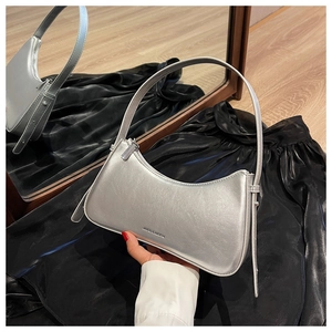 Close-up of a silver crescent hobo bag with adjustable strap and branding detail