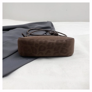 Detail of leopard print suede shoulder bag featuring slim straps and knot accents