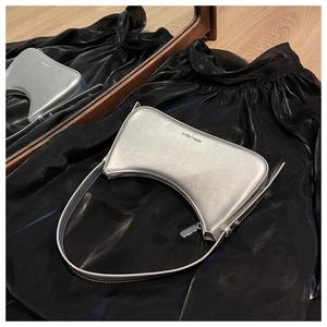 Macro detail of silver mirror finish leather hobo bag with sleek metallic shoulder strap