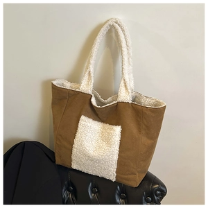 Detail of a brown suede tote bag featuring white sherpa trim and a plush front pocket