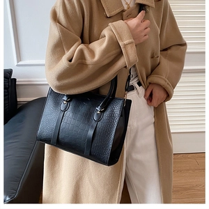 Classic black crocodile pattern tote bag shown with gold rivets and sleek shoulder strap