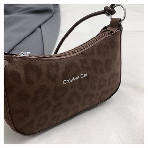 Detail of leopard print baguette bag featuring silver Creative Cat logo and suede texture