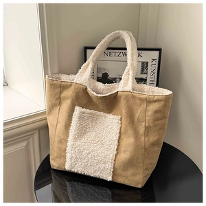 Close-up of contrast faux shearling trim on a brown suede winter tote bag with outer pocket