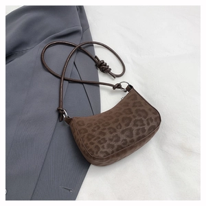Detail of leopard print shoulder bag with knotted strap and silver hardware on a blazer