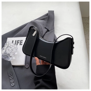 Detail of a black crescent moon shoulder bag with silver hardware and branding logo