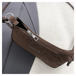 Detailed close-up of dark brown leopard print shoulder bag with Creative Cat lettering