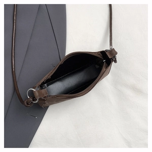 Top view of deep brown faux leather crossbody bag with zipper and black fabric lining