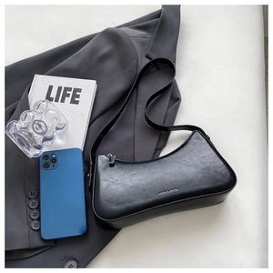 Detail showing internal capacity of the black crescent shoulder bag with a smartphone reference