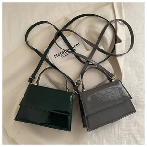 Détail des sacs carrés en cuir verni structuré en vert foncé et gris fumé