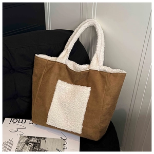 Detail of a brown faux suede tote bag with sherpa trim and oversized front pocket