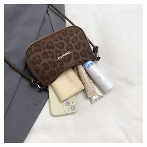 Detail view of leopard print shoulder bag capacity with phone, card holder and cosmetics