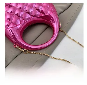 Detail of rose pink metallic quilted handbag with chain strap and rounded handle