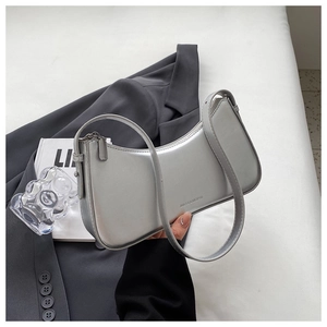 Detail of silver crescent shoulder bag with smooth texture and sleek brand lettering