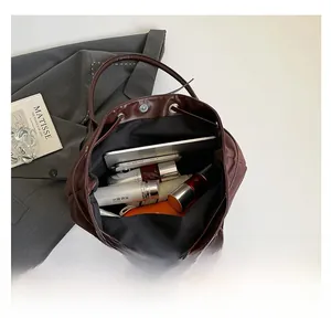 Spacious interior of dark brown tote bag holding tablet, phone, and daily essentials