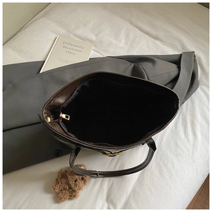 Interior view of large brown leather tote bag with black lining and metal zipper detail