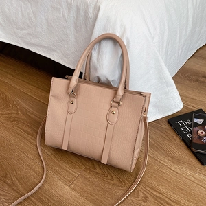Elegant beige crocodile pattern handbag with top handles and adjustable shoulder strap