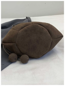 Close-up of the polygonal base on this dark brown suede bucket bag with ball details