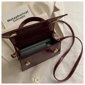 Détails de l'intérieur du sac en cuir verni bordeaux montrant la capacité de rangement