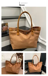 Detail of a brown matte suede tote bag with metal eyelets and a vintage strap buckle