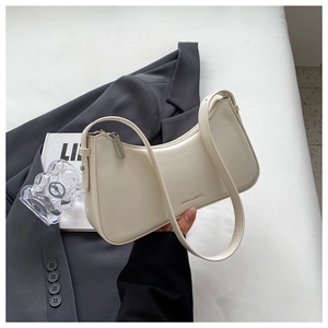Detail showing cream white crescent underarm bag with metal zipper and printed brand logo