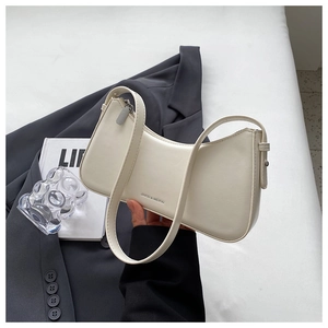 Detail of minimalist cream half-moon underarm bag with smooth leather finish and branding