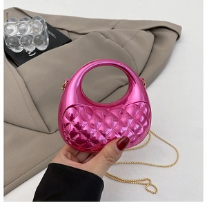 Macro view of metallic magenta quilted bag with circular handle and gold chain strap