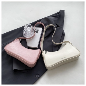 Detail of pink and off-white chic underarm bags with pebbled leather texture on a blazer