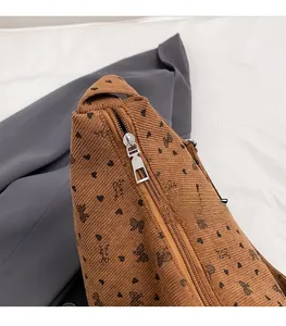 Détail de la fermeture éclair argentée sur un sac fourre-tout en velours marron