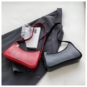 Detail of red and black PU leather underarm bags with silver logo on office blazer