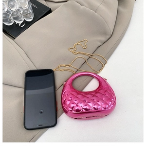 Macro view of rose red metallic quilted mini bag with gold chain and round handle