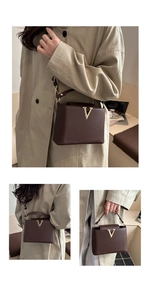 Close-up of brown lychee grain leather crossbody bag with golden V-shaped metal clasp