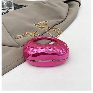 Detail of rose red acrylic evening bag with rhombus pattern and gold chain strap