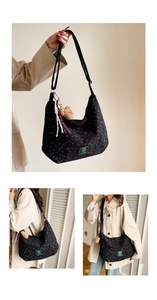 Détail du sac hobo en velours noir avec motifs de cœur et breloque ours incluse
