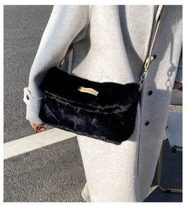 Détail du sac bandoulière en fausse fourrure noire avec étiquette cuir et fermoir argent